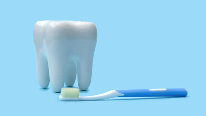 False teeth and toothbrush on a blue background.