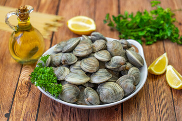 Fresh Littleneck Clams on a white plate with parsley.