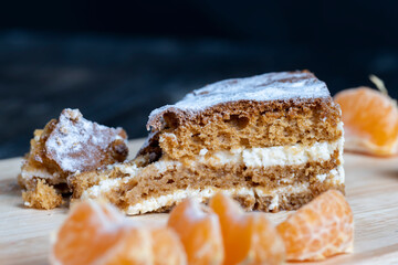 a piece of honey cake with vanilla cream and citrus tangerines
