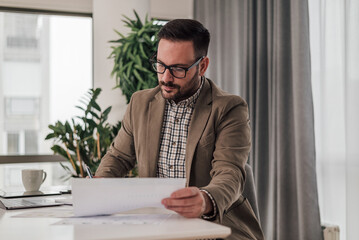 Fototapeta premium Serious professional analyzing business plan while working at corporate office