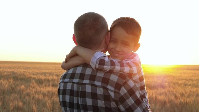 Portrait of a happy child. A child embraces his father at sunset. The concept of a happy family, father and son. father's day