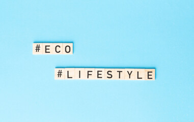 ECO LIFESTYLE sign made by wooden cubes on the side on the blue backhround. Zero waste, ecological concept.