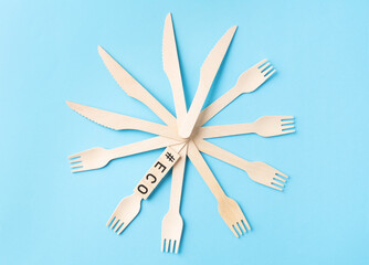 ECO sign made by wooden cubes with wooden cutlery on the side on the blue backhround. Zero waste, ecological concept.