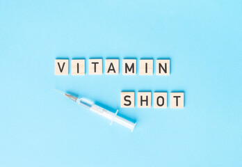 VITAMIN SHOT sign made by wooden cubes with syringe on the side. Medical concept, healthy lifestyle,.