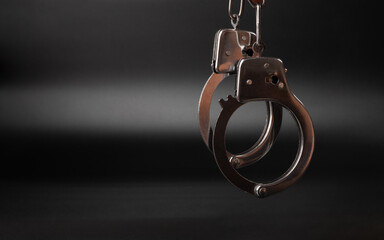 handcuffs on a dark background, concept arrest imprisonment. - obrazy, fototapety, plakaty