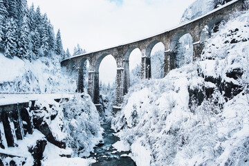 Mountain landscape with Sainte Marie bridge covered with snow in Les Houches, Chamonix valley,...