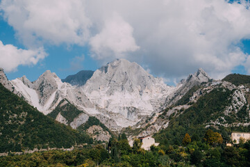 Marble quarry in Carrara, in Tuscany region, Italy. Famous location and place of interest. Mountain town view with white marble rock and blue sky.