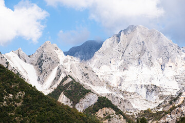 Fototapeta na wymiar Marble quarry in Carrara, in Tuscany region, Italy. Famous location and place of interest. Mountain view with white marble rock and blue sky.