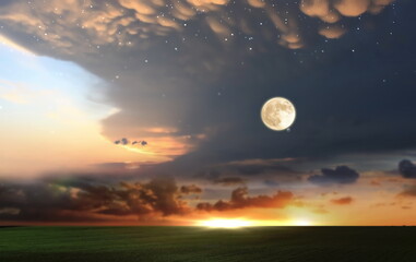 orange dramatic sunset on wild field sun down and moon rise on starry cloudy  sky green grass...