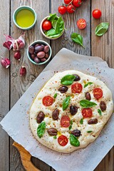 Fresh Italian flat bread (raw) Focaccia with tomatoes, olives, garlic and herbs on a wooden background.