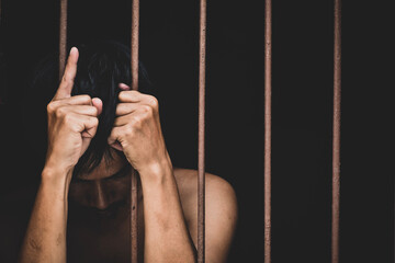 male inmate in prison lift hand to make a wish and pray on black background.concept for...