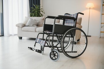 Fototapeta na wymiar Empty wheelchair in the livingroom. Lonely and healthcare concept.