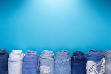 Folded blue jeans denim on paper background texture. Jeans fabric material