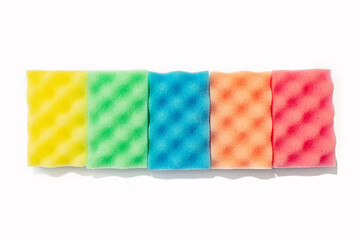 Stack of colorful kitchen cleaning sponges on white background.