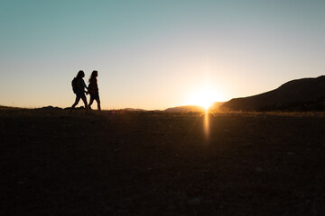 Fototapeta premium two people walk along a mountain range