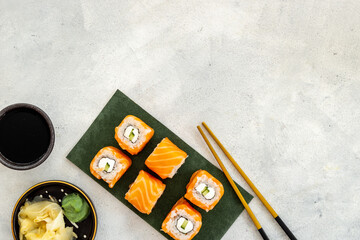 Sushi rolls set with salmon eco served on green papper plate, top view