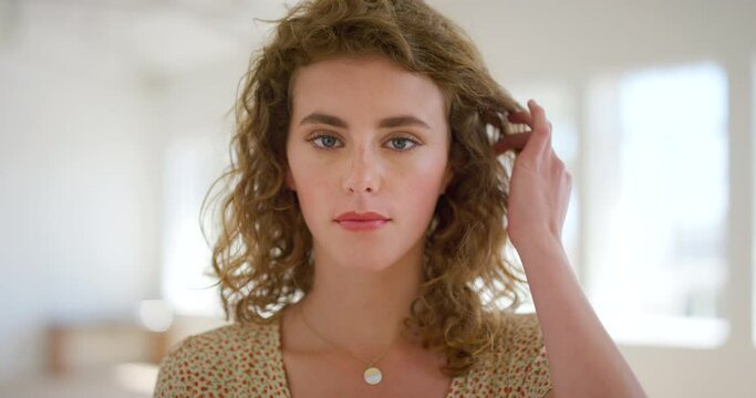 Portrait of seductive woman showing haircare, touching her hair alone inside a room. Closeup of a flirty and confident woman brushing her hair out of her face and looking sexy with copy space