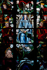 Fototapeta na wymiar Stained glass in Saint Martin's church, L'aigle : Virgin Mary with lilies surrounded by kings