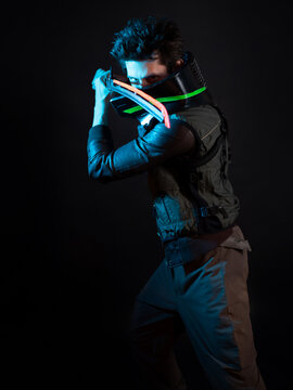 A guy in a cyberpunk image. Cyborg samurai is preparing to attack using a tuned sword. A young man in neon lighting on a black background