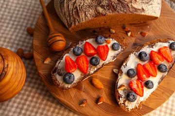 Sandwiches with homemade rye bread, honey, cheese and berries