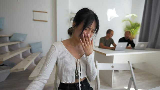 POV of shocked Asian woman feeling bad looking in camera of device. Young brunette grimaces refusing to watch images shown by friend via video call closeup