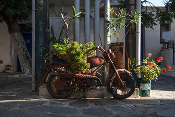 Fototapeta na wymiar Rusty motorcycle in Naxos town in Greece. Beautiful vintage image. 