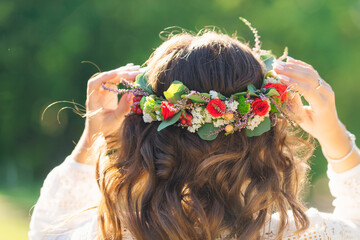 Naklejka premium Close-up of girl's head from back side. curly hair and wreath in Ukrainian national style