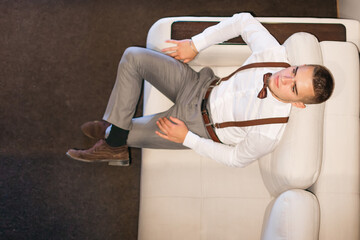 Naklejka premium A top view of the guy sitting on the couch. festive clothes with