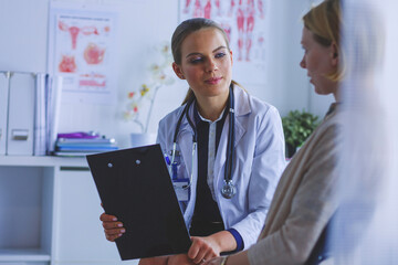 Doctor and patient discussing something while sitting at the table . Medicine and health care concept