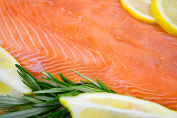 Salmon fillet with lemon and rosemary close-up. Red fish with spices.