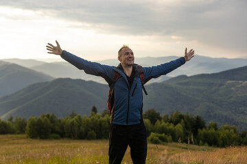 Young man enjoying the view on the top of the mountain. Carpathian mountains, Ukraine
