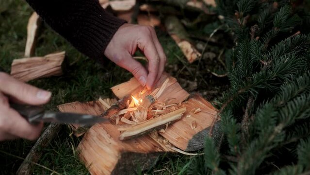 Using a ferro rod fire starter on Fatwood tinder to create a fire