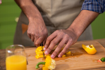 Woman wiping bell pepper with paper towel in kitchen, closeup