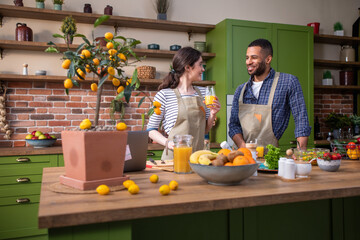 In front of the camera at the kitchen island taking video details multiracial couple hugging hands...