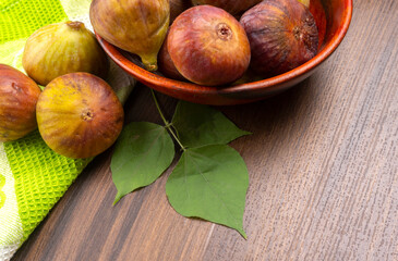 Freshly ripe figs. Healthy Mediterranean fig fruit. Fresh figs on a dark background. Beautiful blue violet figs with leaves, copy space, closeup