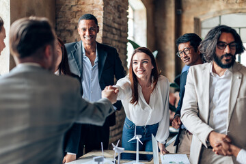 businesspeople at work shaking hands - wind power green energy plan brainstorming © Carlo Prearo
