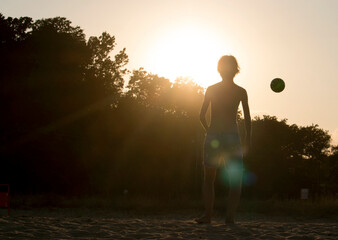 Silhouette of a girl and a ball in golden hour