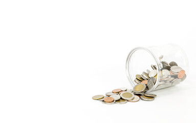 coins pouring out of the can on a white background with copy space.Savings jar with coins scattered around