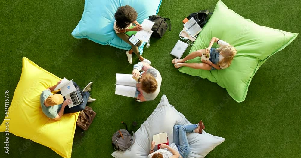 Poster aerial view of professionals using technology, brainstorming on a project in a creative, colourful w