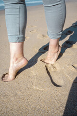 Naked feet of a woman on the sand of a beach