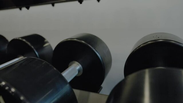 Design and equipment in modern gym. Modern of gym interior with equipment. Sports equipment in the gym Barbells of different weight on rack.