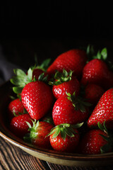 A bowl with ripe bright strawberry in rustic style