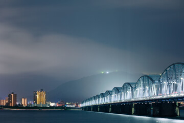 霧に包まれる夜景とトラス橋