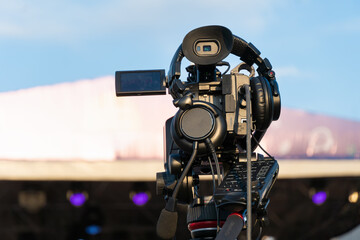 Professional digital video camera shoots video outdoors on a sunny day, rear view