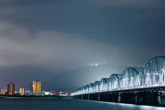 霧に包まれる夜景とトラス橋 © T.Kitajima
