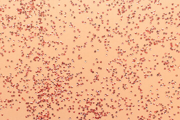 Crystals confetti texture on a gold colored background. Festive concept.