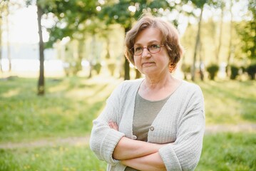 Obraz premium Senior woman walking in the park in summer.