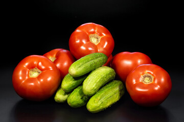 Cucumbers and tomatoes on a black background