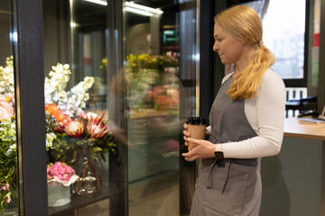 Fototapeta na wymiar florist checks the quality of flowers in the garden refrigerator before starting work