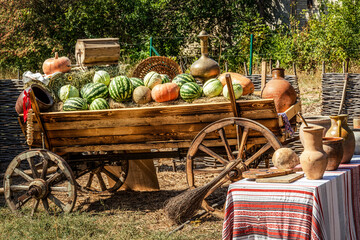 Wooden cart with the harvest. Autumn Harvest Festival - old cart with watermelons, cabbage,...